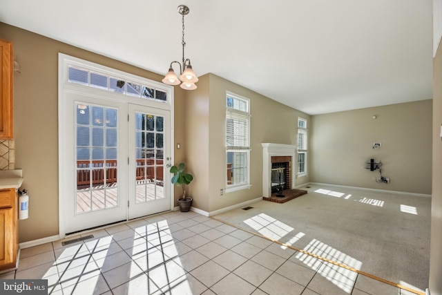 interior space featuring a brick fireplace, visible vents, baseboards, and light tile patterned floors