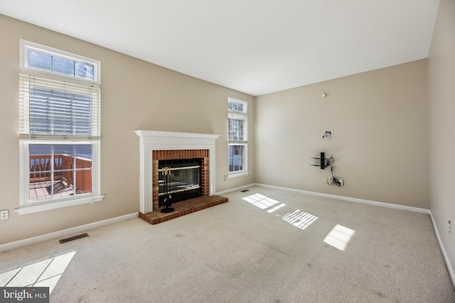 unfurnished living room featuring carpet, baseboards, a fireplace, and visible vents