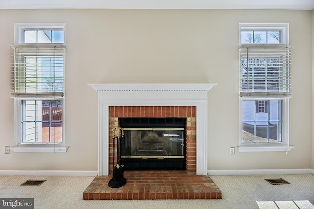 details featuring a brick fireplace, carpet flooring, visible vents, and baseboards