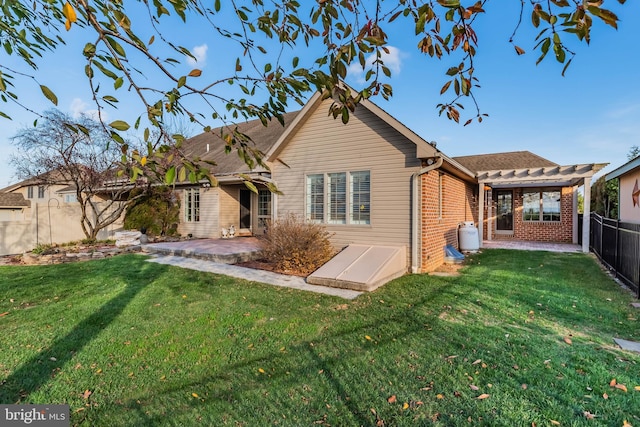 rear view of property with a yard and a patio