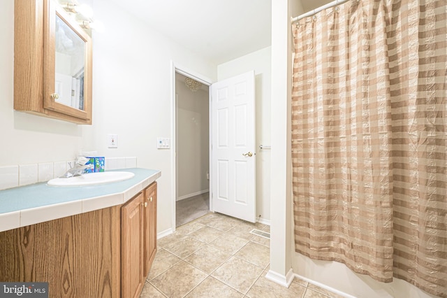 bathroom with shower / bath combination with curtain, tile patterned floors, and vanity