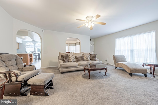 carpeted living room with ceiling fan