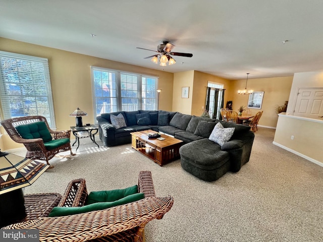 carpeted living room with ceiling fan with notable chandelier