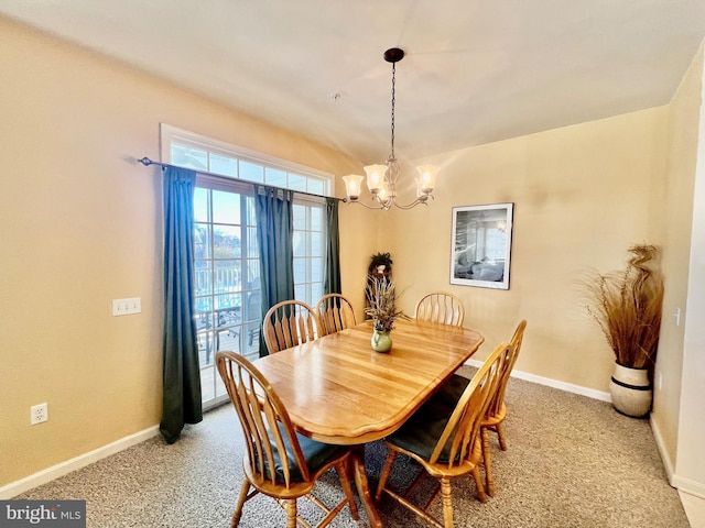 dining area with carpet flooring and a notable chandelier