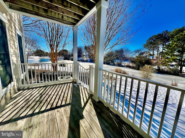 snow covered deck featuring a water view