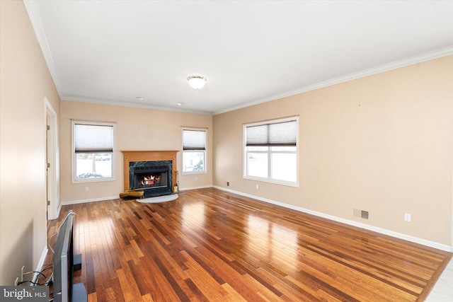 unfurnished living room featuring hardwood / wood-style floors, a high end fireplace, and ornamental molding