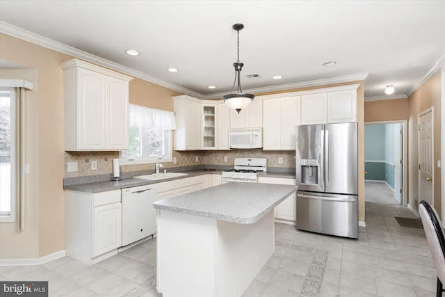 kitchen featuring decorative light fixtures, sink, light tile patterned floors, white appliances, and a kitchen island