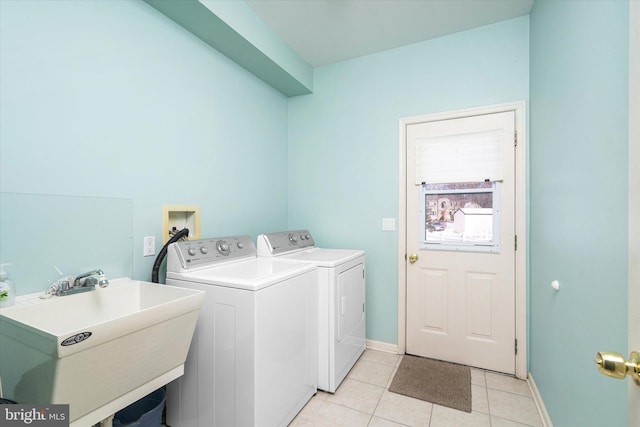 washroom featuring sink, washer and clothes dryer, and light tile patterned floors