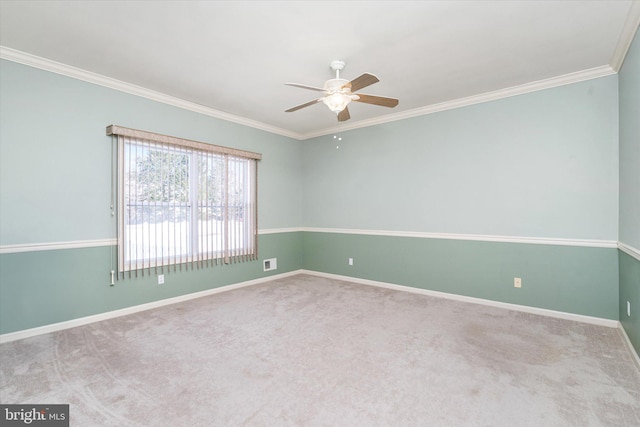 carpeted spare room featuring ceiling fan and ornamental molding