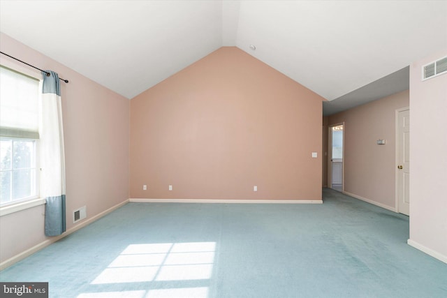 unfurnished room with light colored carpet and vaulted ceiling