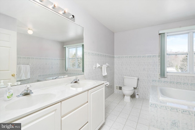 bathroom with tile patterned flooring, tile walls, toilet, a bathing tub, and vanity