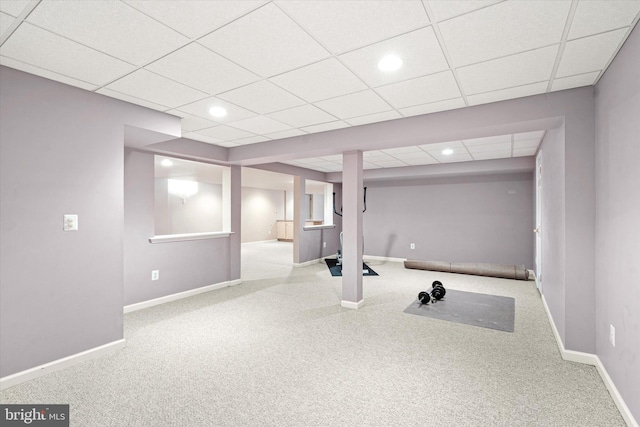 workout area featuring a paneled ceiling and light carpet