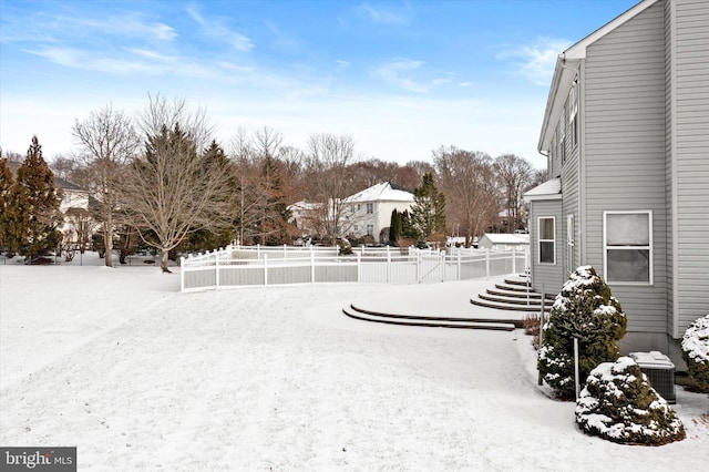 yard layered in snow featuring central AC unit