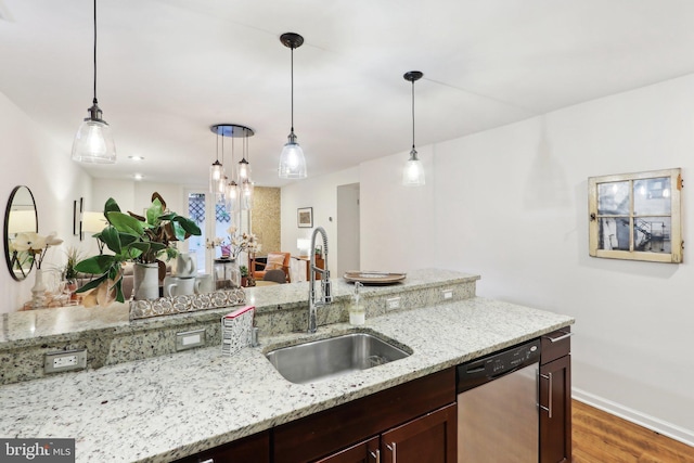 kitchen with sink, decorative light fixtures, light stone countertops, and dishwasher