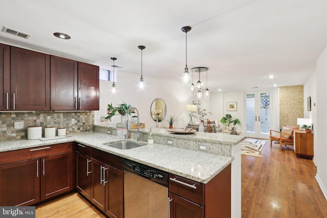 kitchen featuring dishwasher, sink, hanging light fixtures, kitchen peninsula, and plenty of natural light