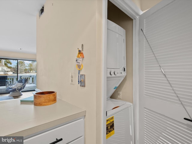 clothes washing area with stacked washer and dryer