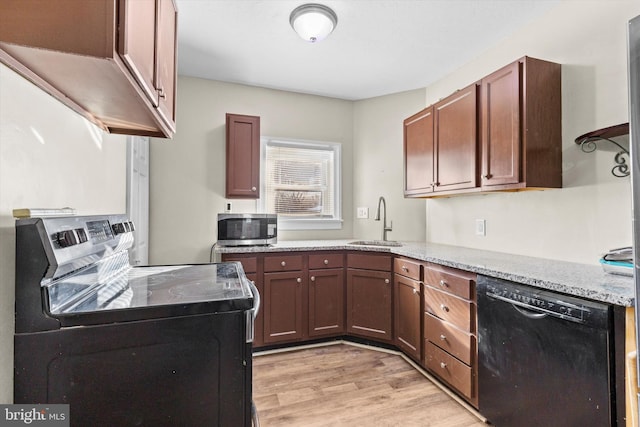 kitchen featuring sink, light stone countertops, stainless steel appliances, and light hardwood / wood-style flooring