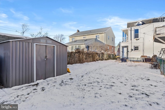 yard layered in snow featuring a storage unit