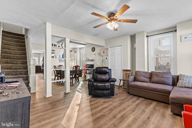 living room with ceiling fan, hardwood / wood-style floors, and a textured ceiling