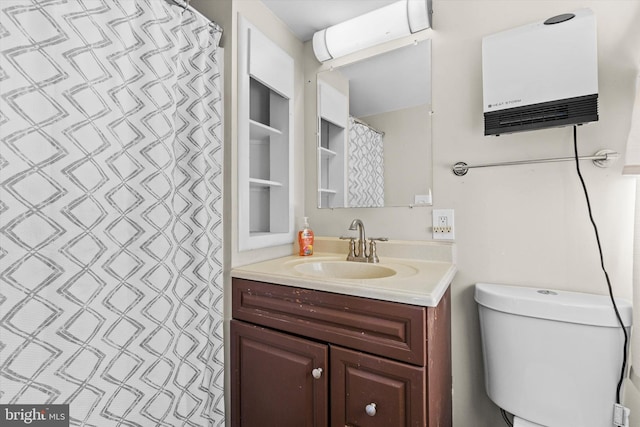 bathroom featuring built in features, vanity, toilet, and water heater