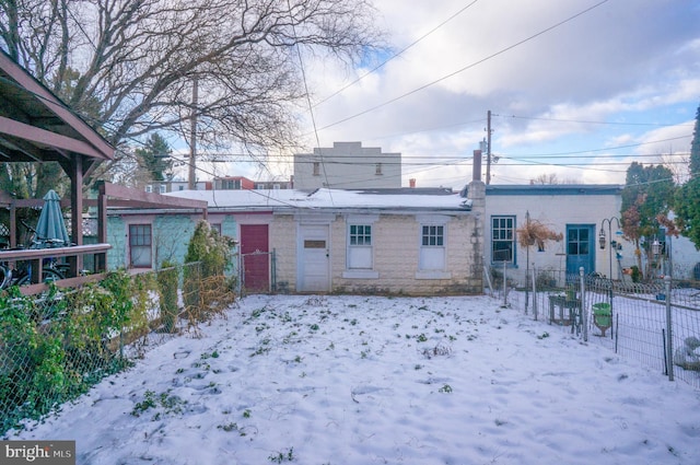 view of snow covered back of property