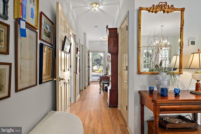 corridor featuring a chandelier and light wood-type flooring