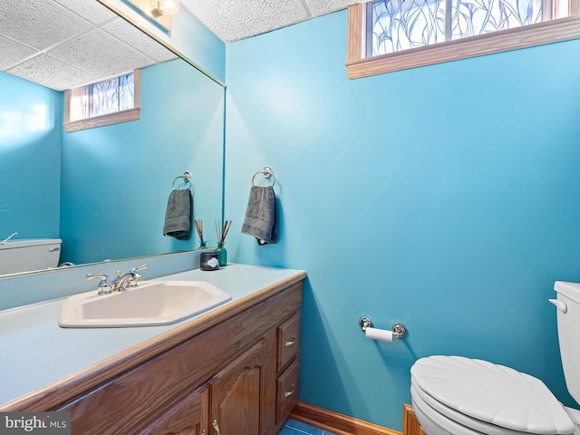 bathroom featuring toilet, a paneled ceiling, and vanity