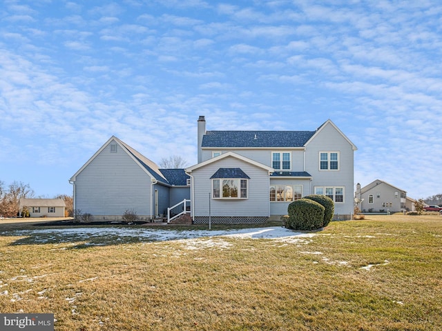 rear view of house featuring a lawn