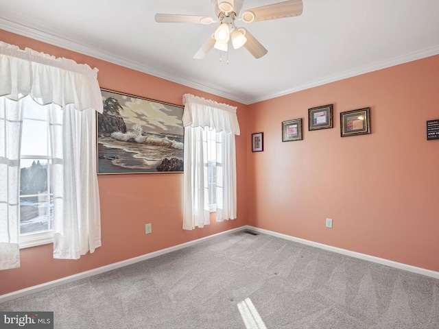 carpeted spare room featuring ceiling fan and crown molding