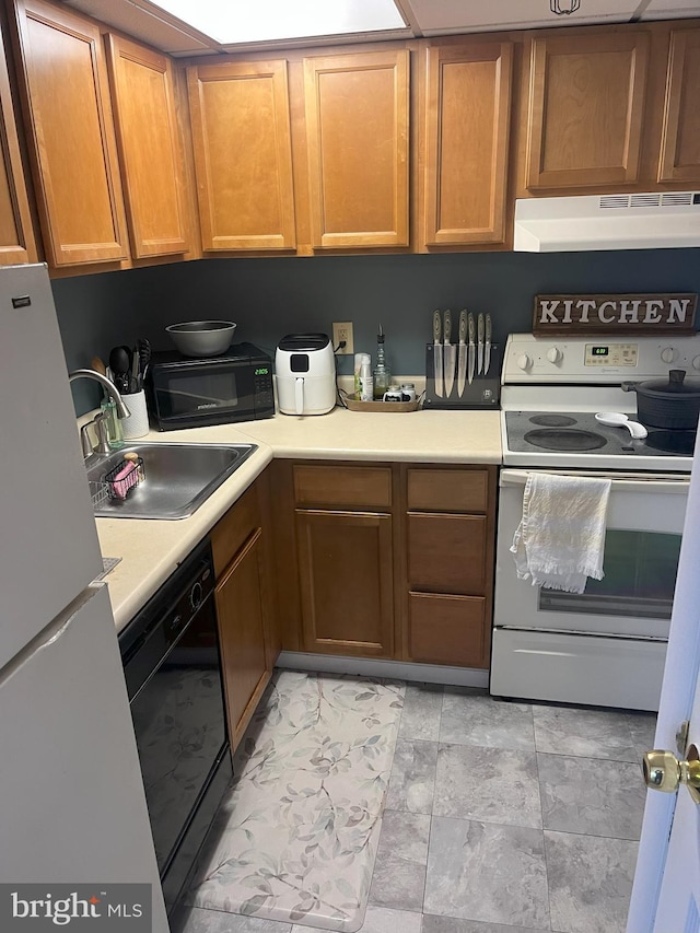 kitchen featuring black appliances, sink, and exhaust hood