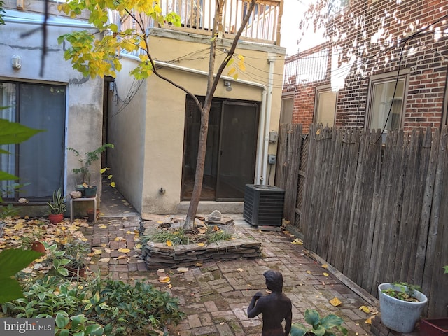 view of patio with cooling unit and a balcony