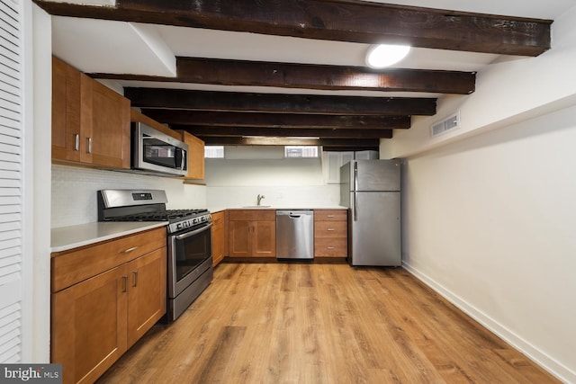 kitchen with sink, light hardwood / wood-style flooring, stainless steel appliances, beam ceiling, and backsplash