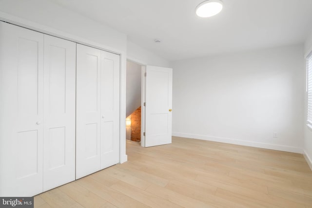 unfurnished bedroom featuring light hardwood / wood-style floors and a closet