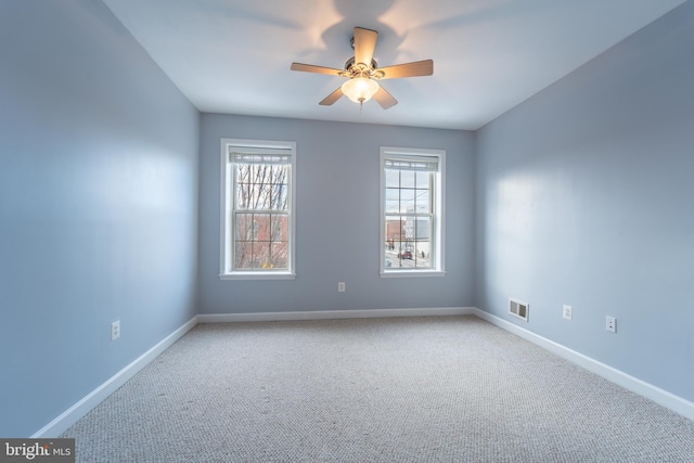 carpeted spare room featuring ceiling fan