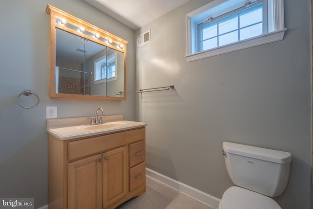 bathroom with toilet, vanity, and tile patterned flooring