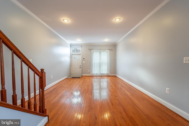 foyer entrance with light wood-type flooring and ornamental molding