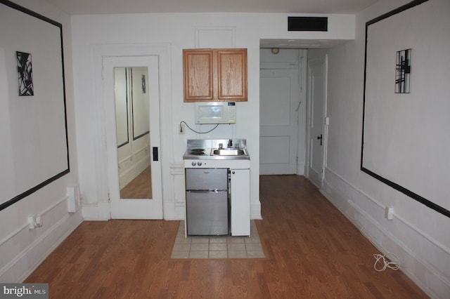 kitchen with dark wood-type flooring and light brown cabinets