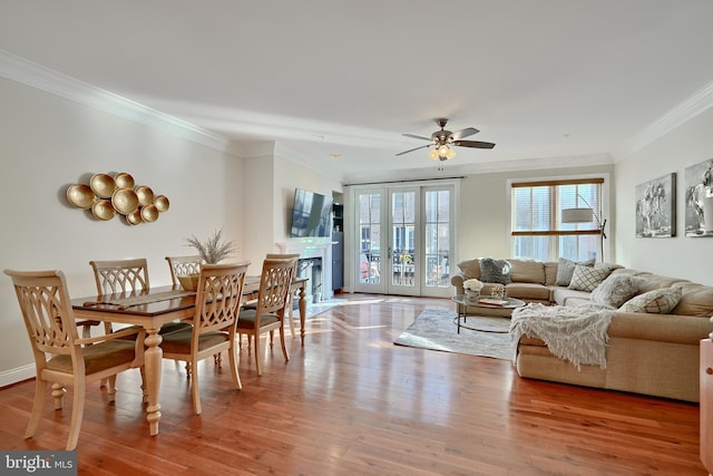 living room with hardwood / wood-style flooring, ceiling fan, and ornamental molding