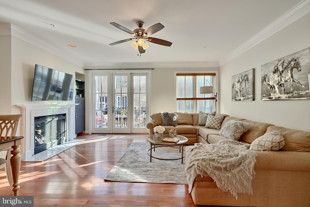 living room with ornamental molding, ceiling fan, hardwood / wood-style floors, and a high end fireplace