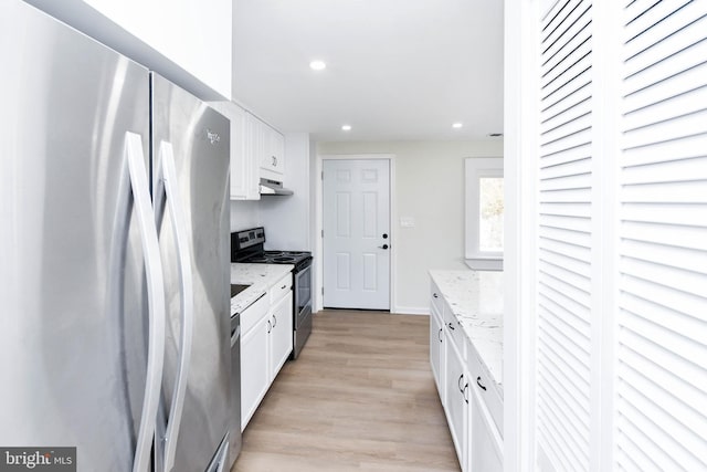 kitchen with light stone countertops, stainless steel appliances, white cabinetry, and light hardwood / wood-style flooring