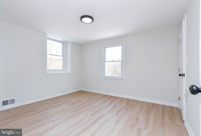 empty room with light wood-type flooring and a wealth of natural light