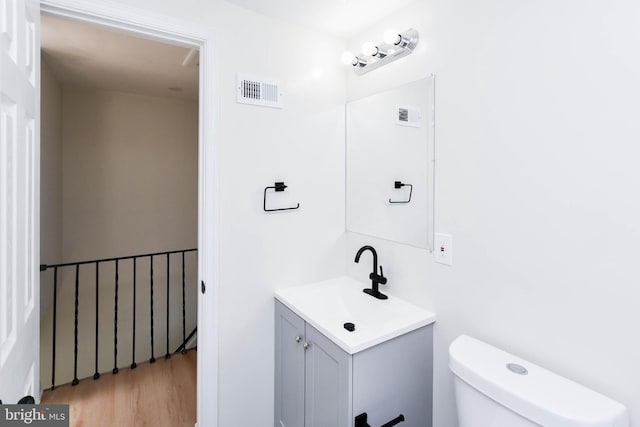 bathroom featuring hardwood / wood-style floors, vanity, and toilet