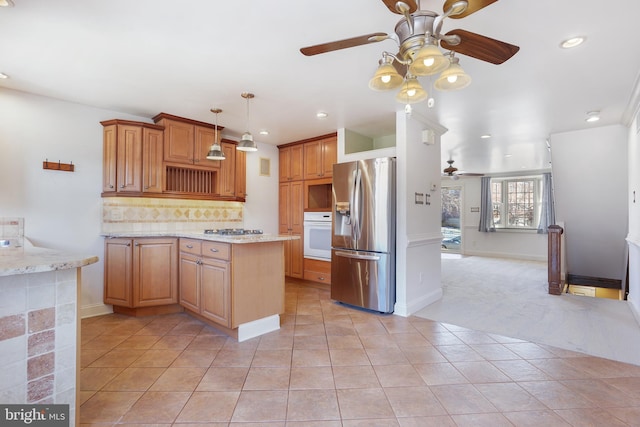 kitchen with light stone countertops, ceiling fan, tasteful backsplash, light colored carpet, and appliances with stainless steel finishes