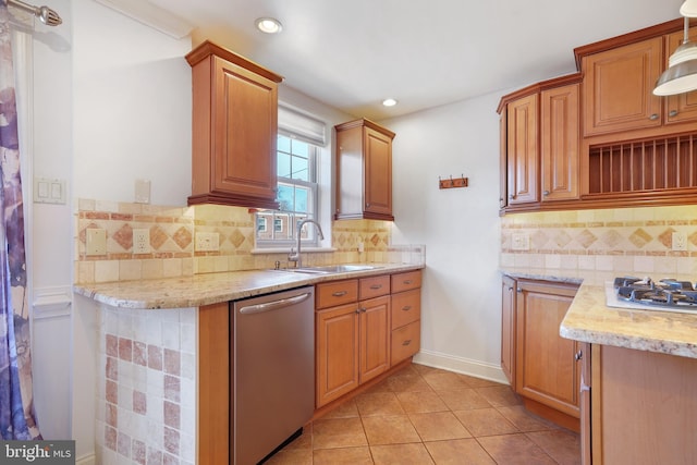 kitchen with backsplash, sink, light stone countertops, light tile patterned floors, and appliances with stainless steel finishes