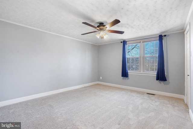 spare room featuring light carpet, a textured ceiling, ceiling fan, and ornamental molding