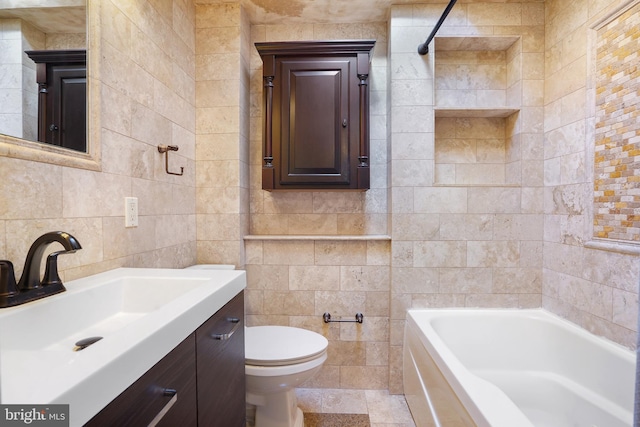 bathroom with a bath, vanity, toilet, and tile walls