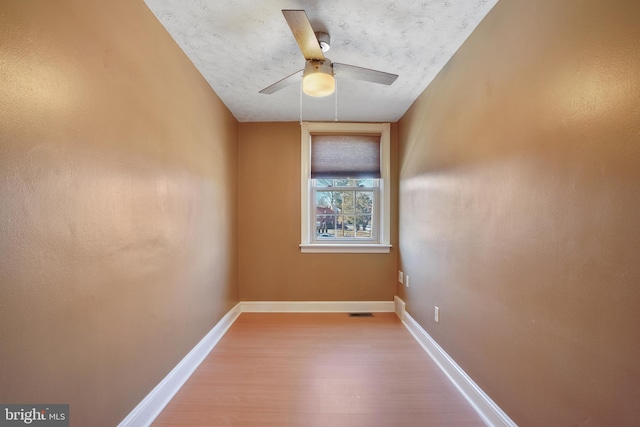 empty room with ceiling fan, hardwood / wood-style floors, and a textured ceiling