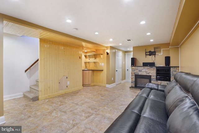 living room featuring wood walls, a fireplace, and beverage cooler