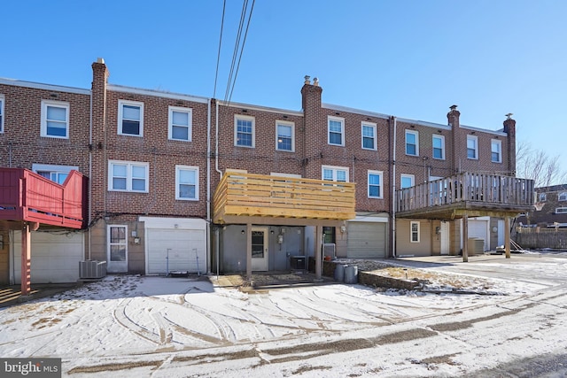 snow covered rear of property with central AC unit