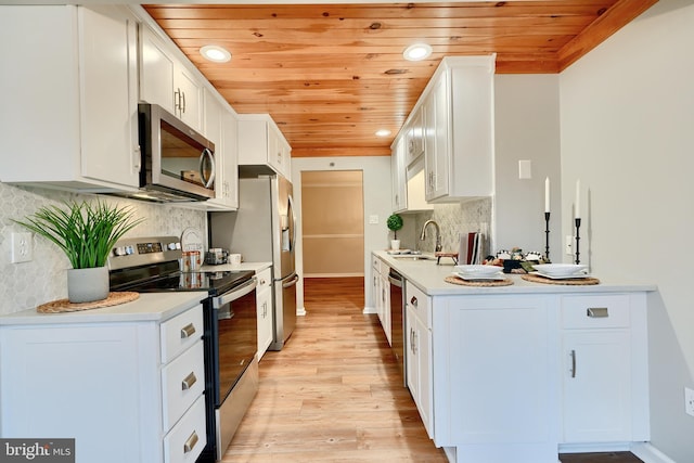 kitchen featuring wood ceiling, stainless steel appliances, decorative backsplash, white cabinets, and sink